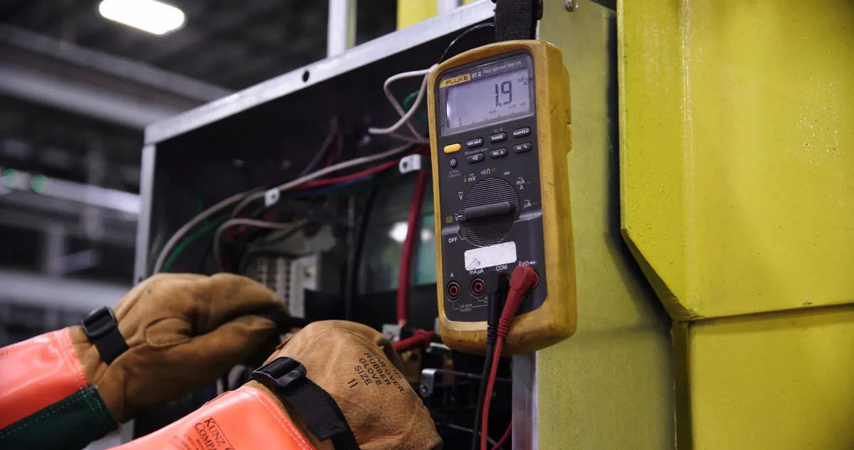 Dłoń trzymająca miernik elektryczny podczas pomiarów instalacji